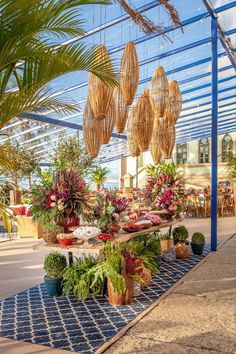 an outdoor market with lots of potted plants and hanging baskets on the ceiling above it