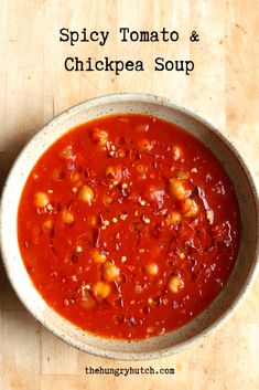 a bowl of spicy tomato and chickpea soup on a wooden table with the title above it