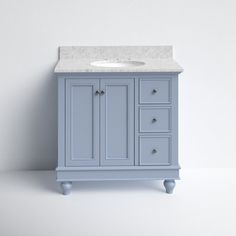 a white sink sitting next to a blue cabinet