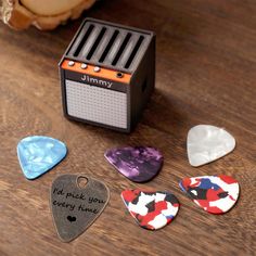 four guitar picks sitting on top of a wooden table next to a toaster and an old radio