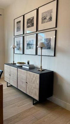 a black and white sideboard with pictures on the wall