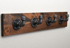 a wall mounted coat rack with five different knobs on it's sides and two hooks in the middle