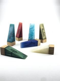 five different colored wooden blocks sitting next to each other on top of a white surface