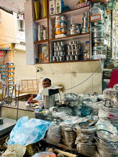 a man standing in front of a store filled with lots of items