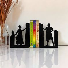 two bookends made out of black metal with silhouettes of children holding hands