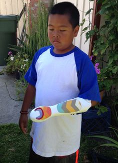 a young boy holding a plastic bat in his hands