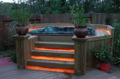 an outdoor hot tub lit up with orange lights