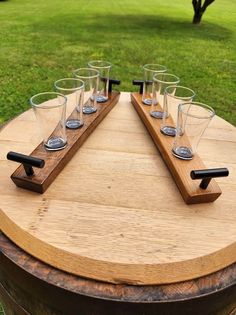 a wooden table topped with glasses on top of a barrel