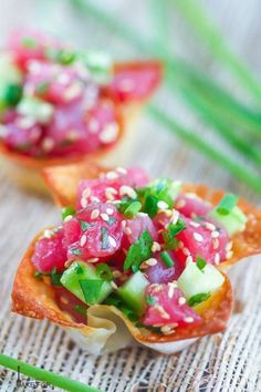 three small appetizers with vegetables and sauce on them are sitting on a table