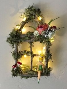 a doll sitting on top of a window with fairy lights