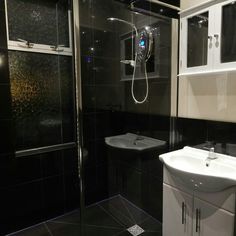 a black and white bathroom with glass shower doors