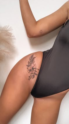 a woman with a tattoo on her back laying next to a white wall holding a cell phone