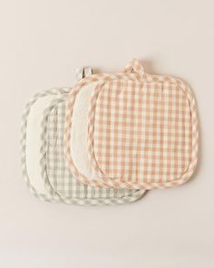 three baby bibs in various colors and patterns on a white background, each with a checkerboard design