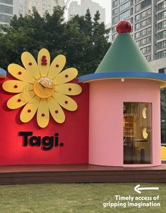 there is a sign that says tagi in front of a building with a flower on it