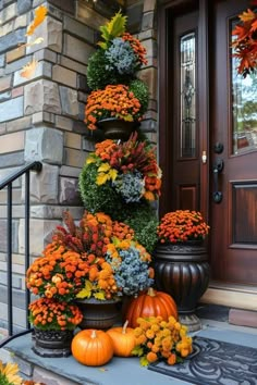 a tall planter filled with lots of flowers sitting on top of a step next to a door