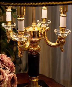 a gold and black candelabra with candles on it sitting on a table