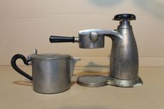 an old fashioned coffee pot and saucer on a table