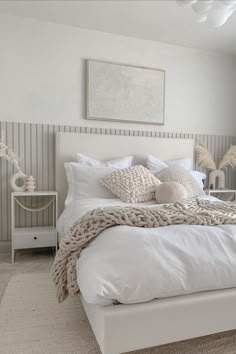 a white bed sitting in a bedroom next to a window