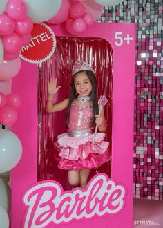 a barbie doll in a pink box with balloons