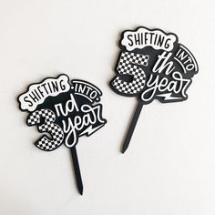 two black and white cake toppers with sayings on them