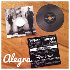 an album and cd sitting on top of a wooden table next to a black record