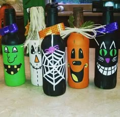 halloween wine bottles with faces painted on them