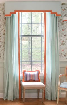 an orange and blue chair sitting in front of a window