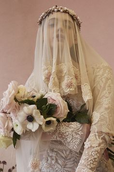 a woman wearing a veil and holding a bouquet of flowers