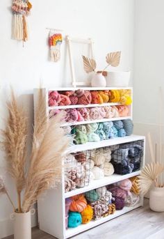 a white shelf filled with lots of yarn