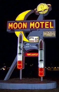 the moon motel sign is lit up at night with lights on it's sides