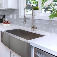 a bowl of cherries sits on the kitchen counter next to an oven and dishwasher