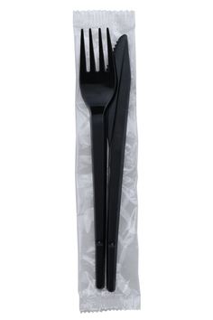 two black plastic forks sitting on top of a white wrapper with the fork in it