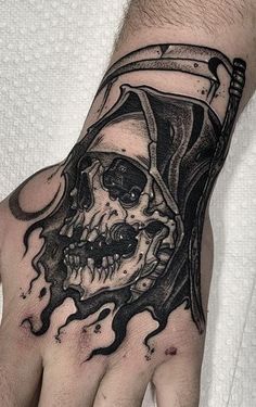 a man's hand with a pirate skull tattoo on it