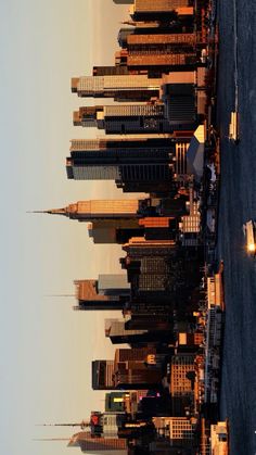 the skyline of new york city is seen from across the water at sunset or dawn