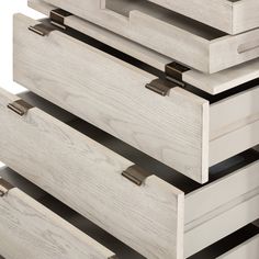 the drawers are made from wood and have metal handles on each one side, while the bottom drawer is painted white