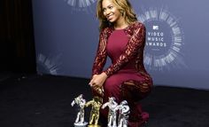 a woman kneeling down next to two trophies