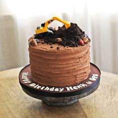 a birthday cake that is on top of a table with a construction truck in the middle