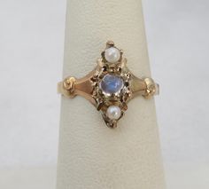 ESTATE VICTORIAN  14K YELLOW GOLD SEED PEARL AND MOONSTONE RING. SIZE 6 GREAT SHAPE. HALLMARK FADDED ACID TESTED FOR  14K. 13MM FACE. 2 GRAMS. PLEASE BE ADVISED SOME PHOTOS ARE CLOSEUPS TO SHOW DETAIL, PLEASE READ FULL DESCRIPTION FOR BETTER UNDERSTANDING OF SIZE.  This item is preloved and Antique/Vintage. This means it may have signs of wear and use and is offered as is.  You will receive the exact item shown in the photos. There may be slight color variation depending on your monitor display. Vintage Moonstone Ring, Victorian Gold Ring, Antique Rings Victorian, Gold Vintage Ring, Seed Pearl Ring, Victorian Ring, Victorian Gold, Victorian Rings, All Gems