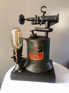 an old fashioned machine with a light on it's side sitting on top of a table