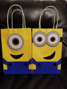 two paper bags with eyes on them sitting on a couch