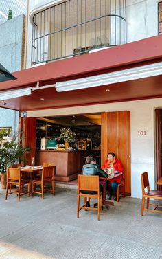 a woman sitting at a table in front of a restaurant