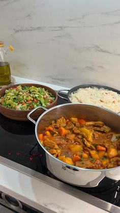 three pans filled with different types of food on top of a gas stovetop