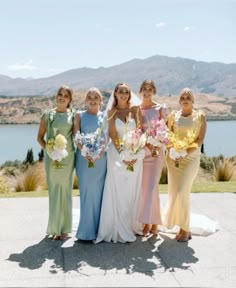 a group of women standing next to each other on top of a cement floor covered field