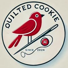 a red bird sitting on top of a white sign that reads quilted cookie since 2024