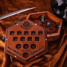 an elaborate wooden box with dices in it and a skull on the table next to it