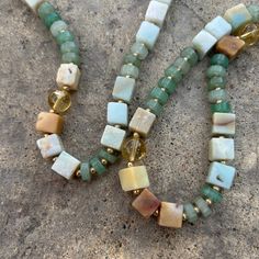 You'll give off nothing but good vibes with the subtle hues in this mixed media natural stone beaded necklace. This piece is perfect worn alone or in a layered #neckmess. Soft tones of sea, sand, and sunshine in geometric shapes of cubes, spheres, and cylinders blend beautifully in this mixed-media necklace. The vibrant gold plated brass spacer beads add contrast and space to the pale hues of amazonite, aventurine, and citrine beads creating a subtle drama inviting a closer look. Citrine Aventur Adjustable Gemstone Beaded Necklace For Beach, Everyday Necklaces With Natural Round Beads, Everyday Natural Stones Round Beads Necklace, Rectangular Gemstone Beaded Necklaces For Gifts, Everyday Necklaces With Round Natural Stones, Bohemian Square Necklace As Gift, Everyday Bohemian Crystal Necklaces With Gemstone Beads, Rectangular Gemstone Beaded Necklace For Gift, Bohemian Square Necklace For Gift