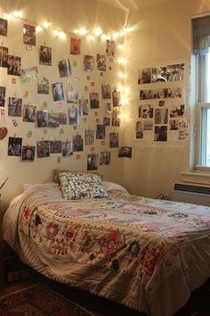 a bed sitting in a bedroom next to a window with pictures on the wall above it