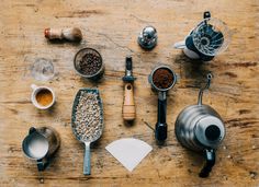 an assortment of kitchen utensils on a wooden table, including measuring cups and spoons