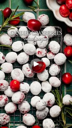 cranberry snowball cookies on a cooling rack with cherries and rosemary sprigs