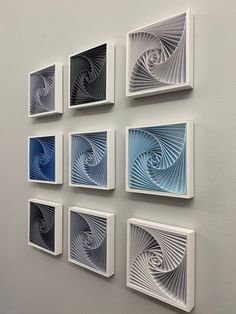 six square white and blue artwork pieces mounted on a wall